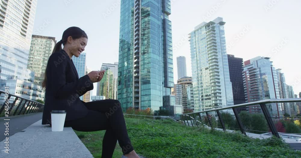 Businesswoman using smart phone in the city. Young woman professional in a big city using smartphone. Vancouver, Canada, Shot on RED. Businesswoman using smart phone in the city. Young woman professional in a big city using smartphone. Vancouver, Canada, Shot on RED.