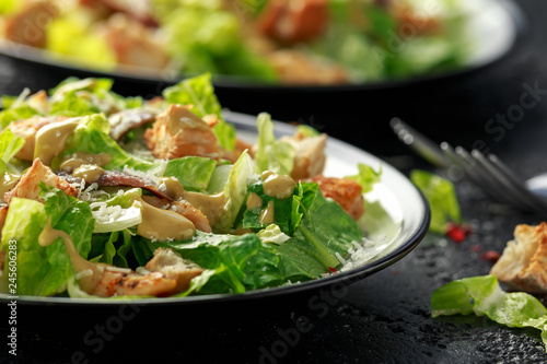 Fototapeta Caesar salad with chicken, anchous fish, croutons, parmesan cheese and greens