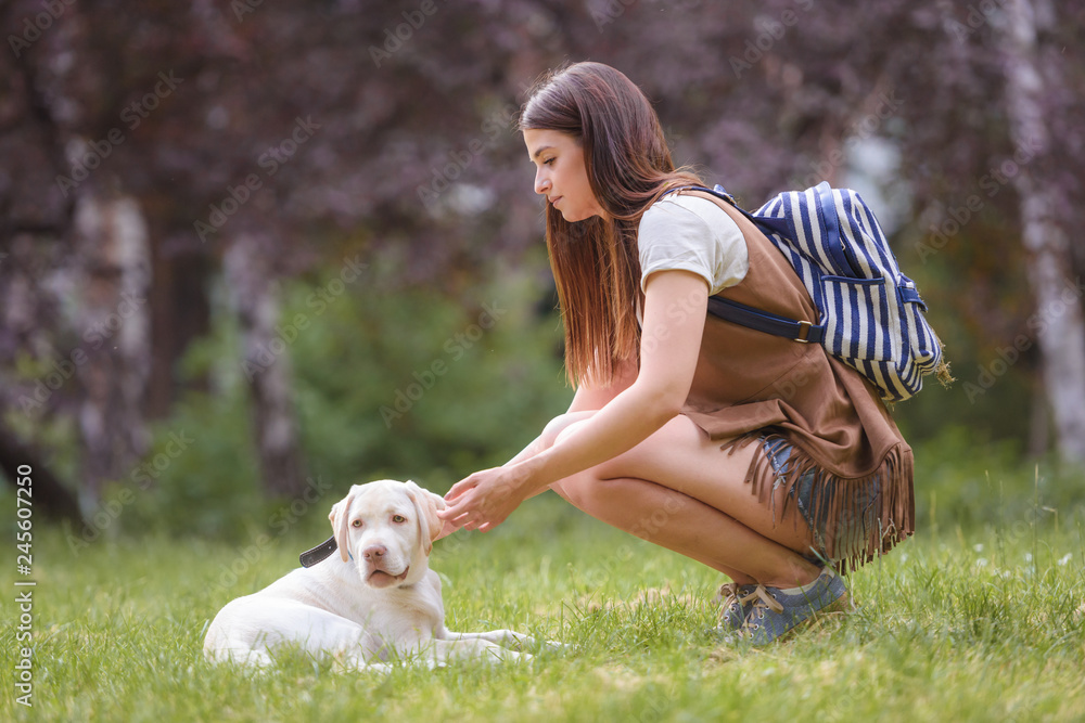Beautiful young woman playing with a puppy labrador in the park Beautiful young woman playing with a puppy labrador in the park