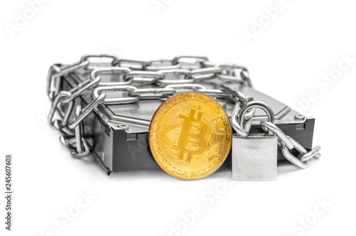  Chain locked by padlock with coin of bitcoin on hard disc drive.