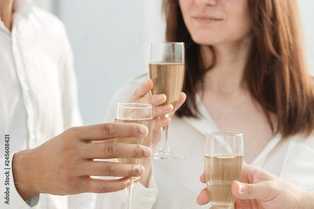 close up. business team raising glasses of wine in the new office. close up. business team raising glasses of wine in the new office.