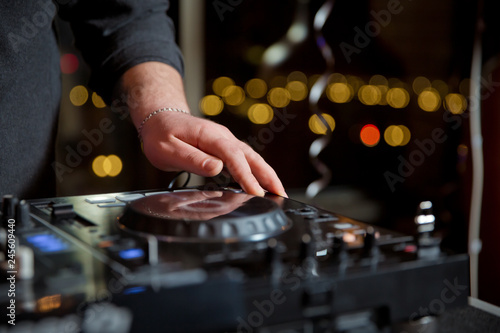Party dj mix music tracks on edm festival in night club.Hands of disc jockey mixing musical set on sound mixer controller in nightclub.Professional turntables sound system