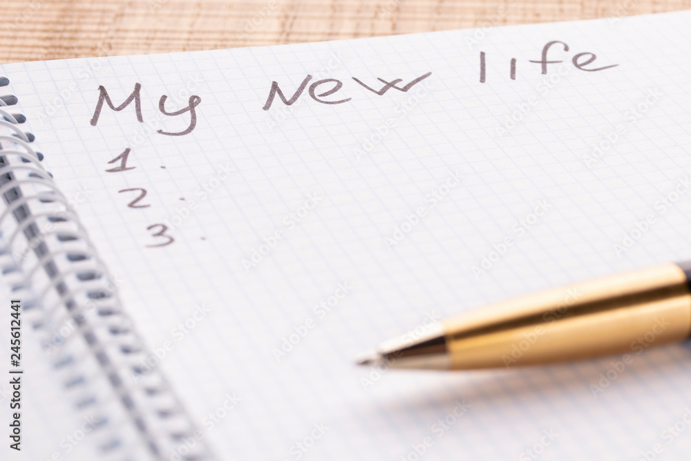 Top view workplace notebook and pen on wood table background, retro effect. The inscription is my new life. Top view workplace notebook and pen on wood table background, retro effect. The inscription is my new life.