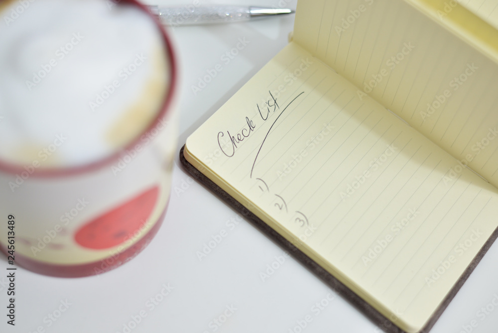 Note book with check marks and a cup of coffee on white background, copy space. Note book with check marks and a cup of coffee on white background, copy space.