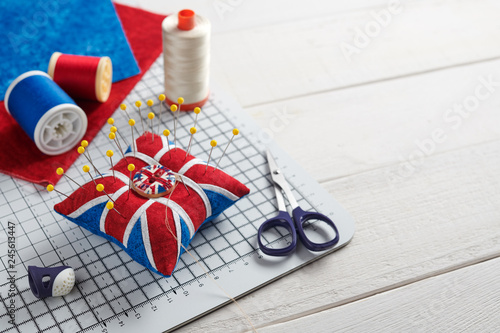 Pincushion like Union Jack on white craft mat, sewing accessories
