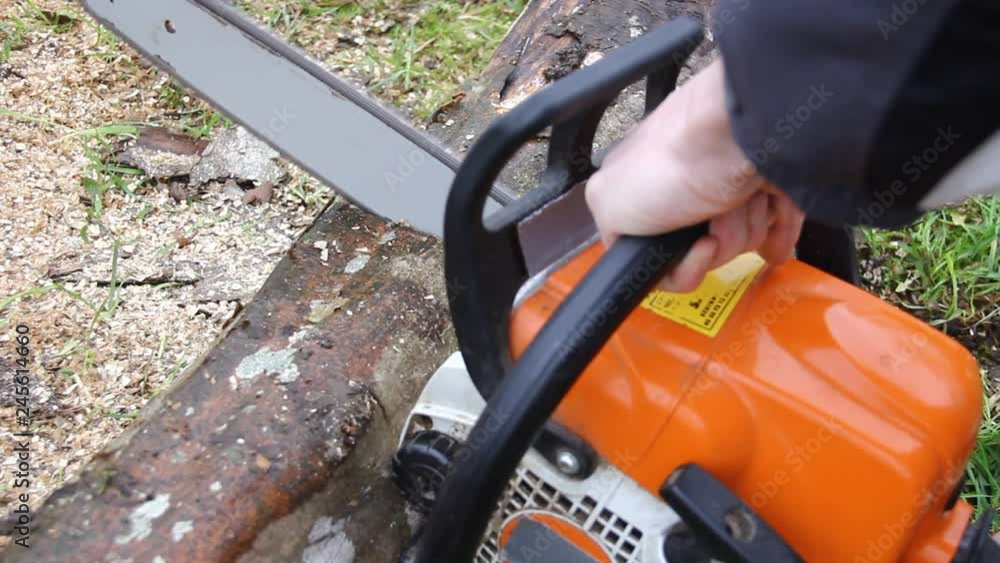 close up of a chainsaw in action cutting through a wood log close up of a chainsaw in action cutting through a wood log