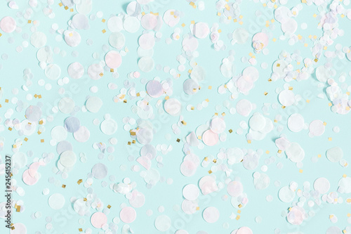Paper confetti on pastel blue background. Party, birthday, wedding, holiday concept. Flat lay, top view, copy space