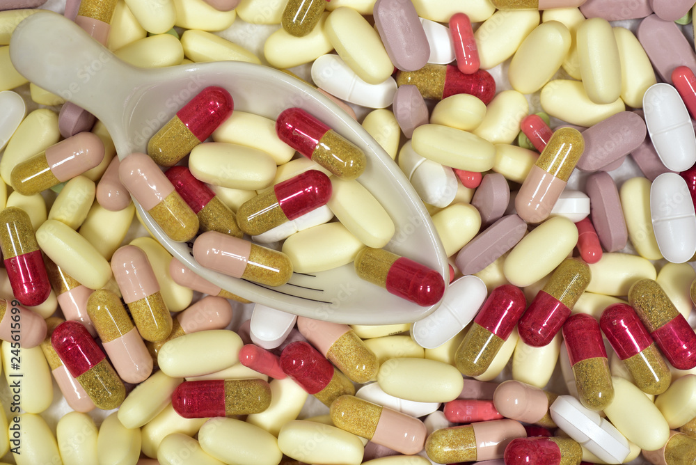 hintergrund mit tabletten und kapseln und einem messlöffel hintergrund mit tabletten und kapseln und einem messlöffel