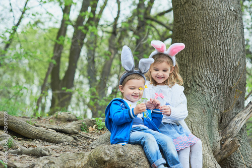 Photography Cute funny girl and boy with Easter eggs at park
