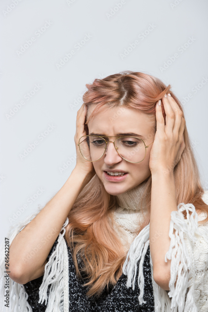Cropped indoor portrait of attractive panicked girl with stylish eyewear holding her head, doesn't know what to do, looking at the floor/confused young female/human emotions, facial expression concept Cropped indoor portrait of attractive panicked girl with stylish eyewear holding her head, doesn't know what to do, looking at the floor/confused young female/human emotions, facial expression concept