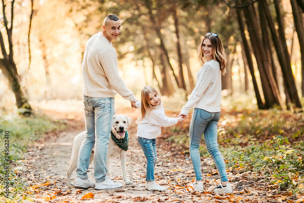 Happy beautiful family with dog labrador is having fun together walking the in park. Happy beautiful family with dog labrador is having fun together walking the in park.
