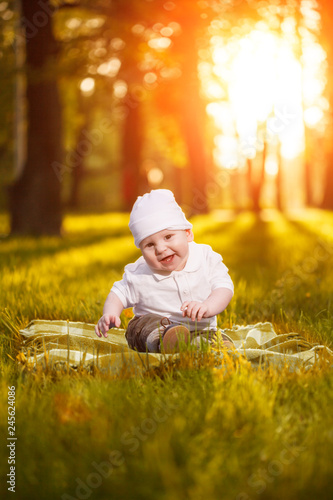 Baby in the park in the rays of sunset. Toddler on the nature outdoors. Backlight. Summertime family  scene