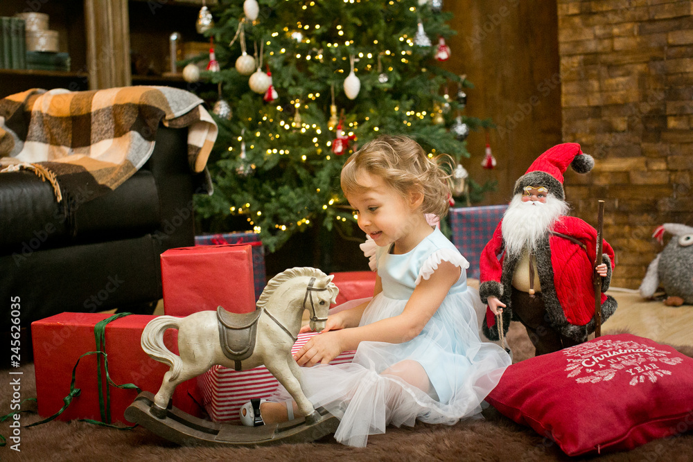 little girl under the christmas tree with christmas gifts little girl under the christmas tree with christmas gifts