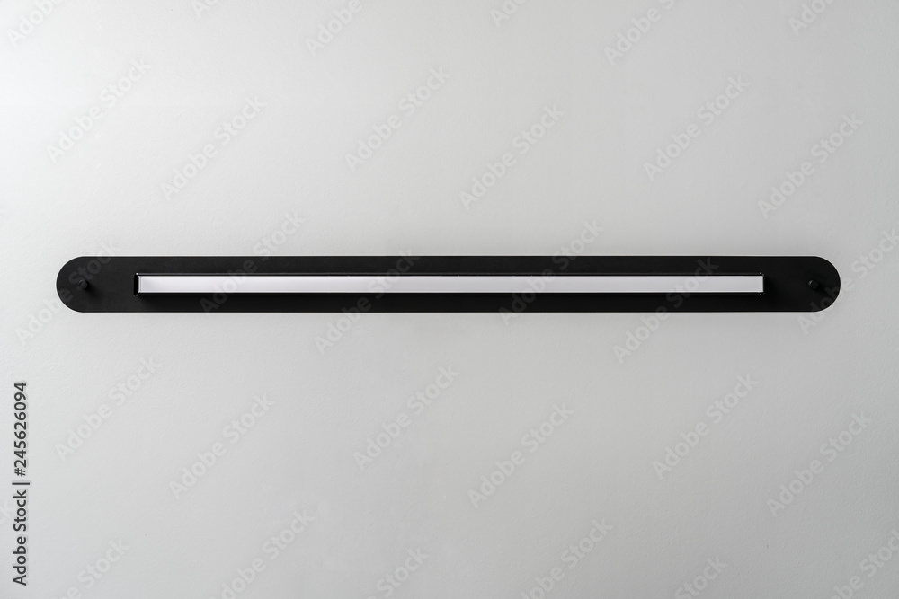 Black metal lamp on gray wall background in studio Black metal lamp on gray wall background in studio