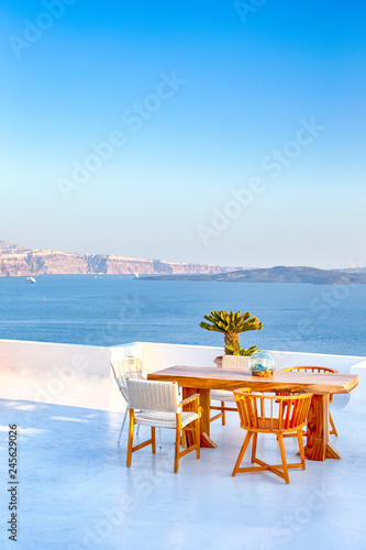 Romantic Tranquil Open Air Cosy Terrace Restaurant in Beautiful Oia Village on Santorini Island in Greece Before the Sunset.