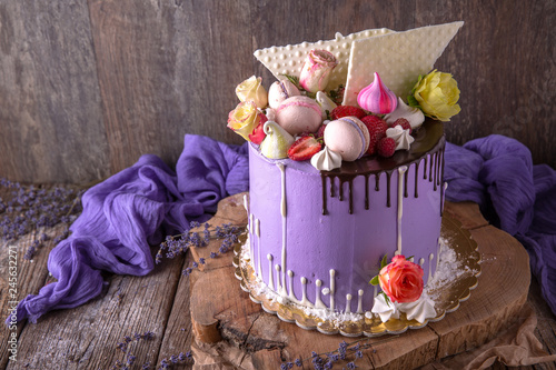 Luxurious Purple cake decorated with a bise, marshmallow, berries and fresh flowers.  Wedding sv. valentine cake