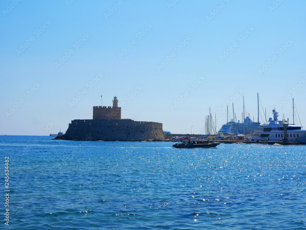 The entrance to Mandraki Harbour on the island of Rhodes Greece