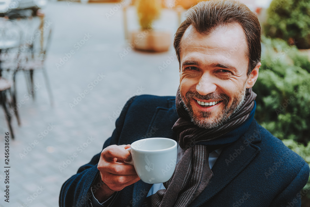 Happy man is having hot drink outside Happy man is having hot drink outside