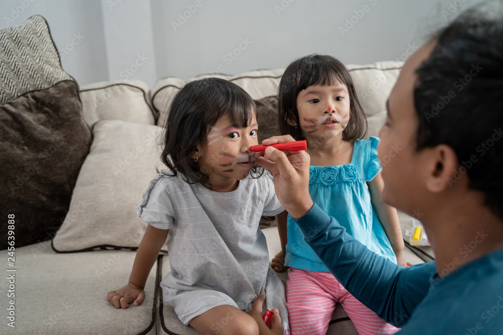 father paint his two daughter in the face father paint his two daughter in the face
