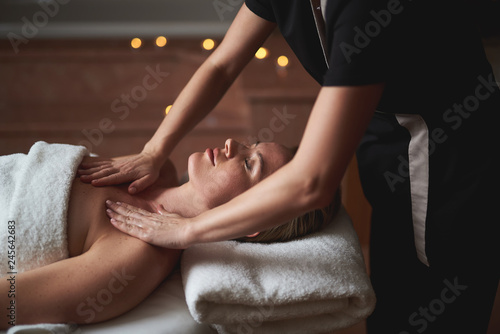 Lady having decollete massage in spa salon photo