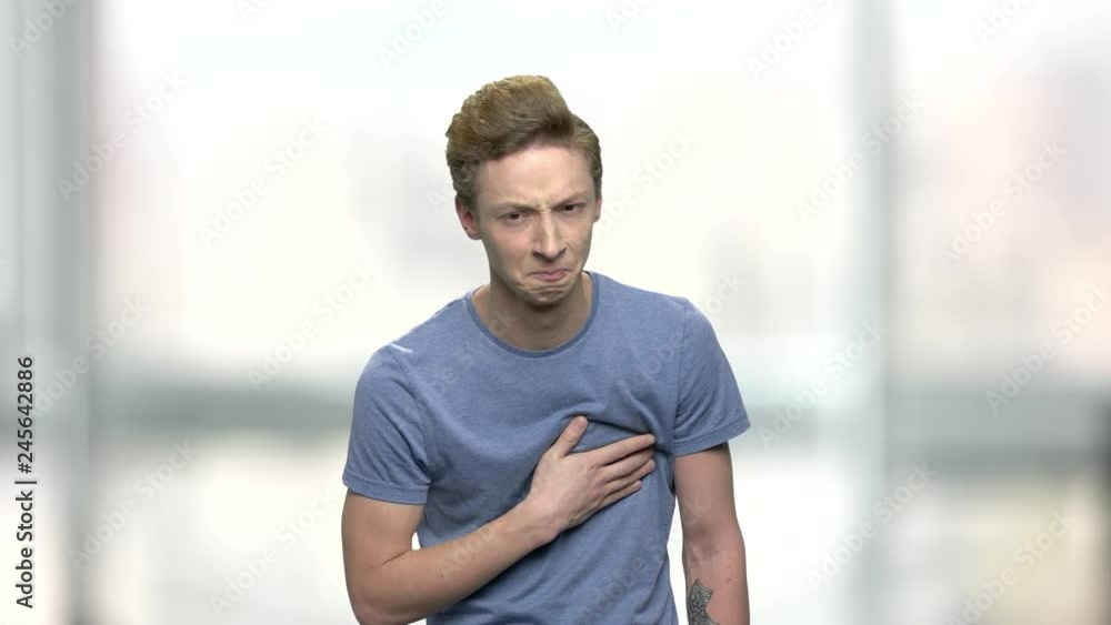 Young caucasian boy suffering from sudden heart attack. Stressed teen guy having strong heart ache. Health problem concept. Young caucasian boy suffering from sudden heart attack. Stressed teen guy having strong heart ache. Health problem concept.