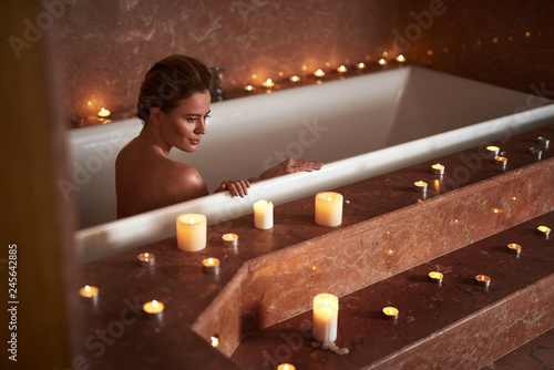 Young lady take relaxed spa bath with candle