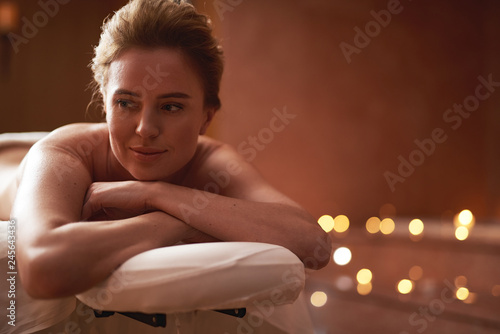 Relaxing young lady enjoying on massage table
