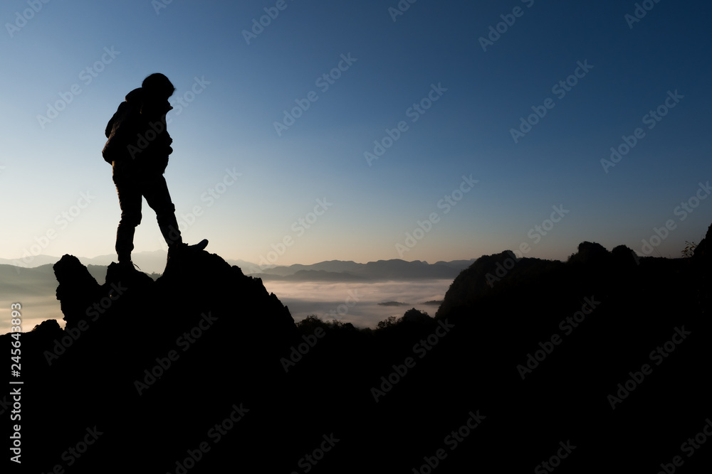 silhouette of climber on the top of mountain