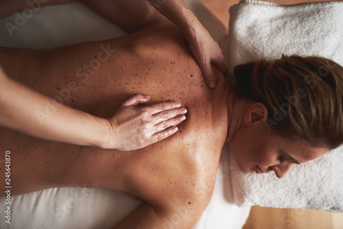 Top view of young lady having massage in spa salon