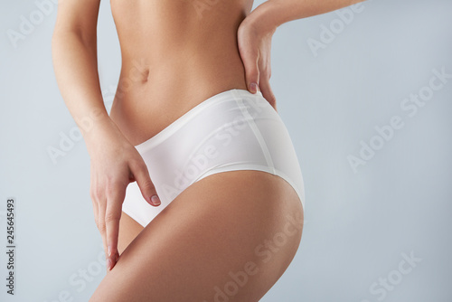 Konstfotografi Young woman in white panties touching her leg