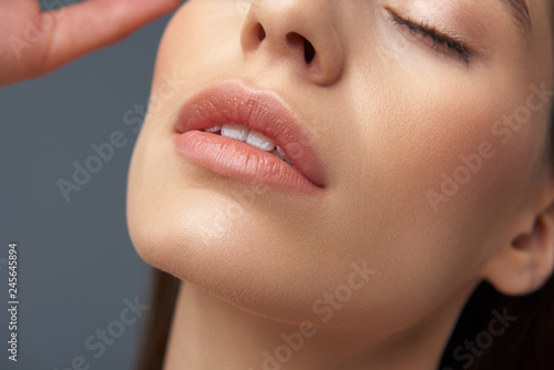 Quadro su tela Attractive girl with slightly opened lips isolated on blue-gray background