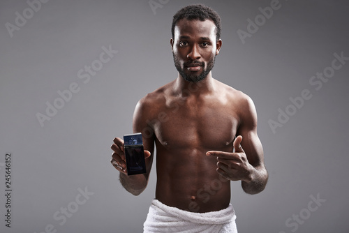 Pleasant young afro American man using cologne after shower © Yakobchuk Olena
