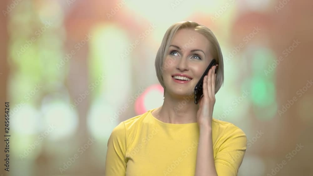 Cheerful blonde woman talking on cell phone. Portrait of a young emotional woman talking on smartphone and gesticulating. Cheerful blonde woman talking on cell phone. Portrait of a young emotional woman talking on smartphone and gesticulating.