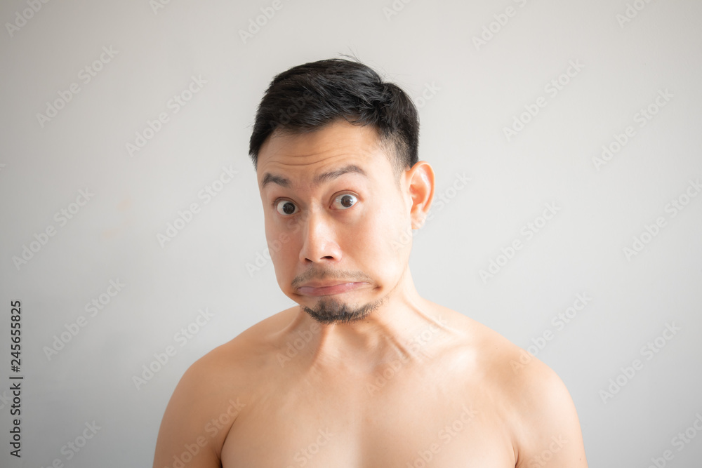Shock and surprise face of Asian man in topless portrait isolated on gray background. Shock and surprise face of Asian man in topless portrait isolated on gray background.