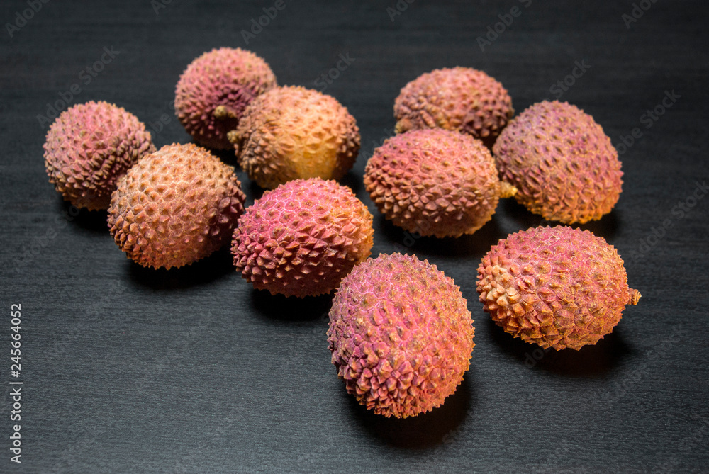 Some few of а berry lychee on black wooden background Some few of а berry lychee on black wooden background