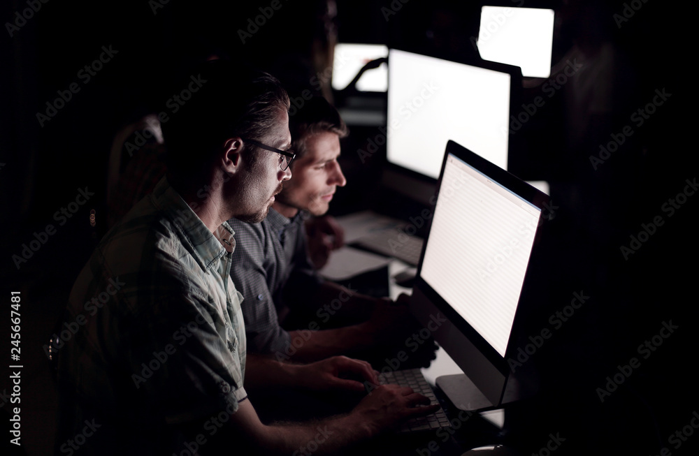 business team works on computers at night. business team works on computers at night.