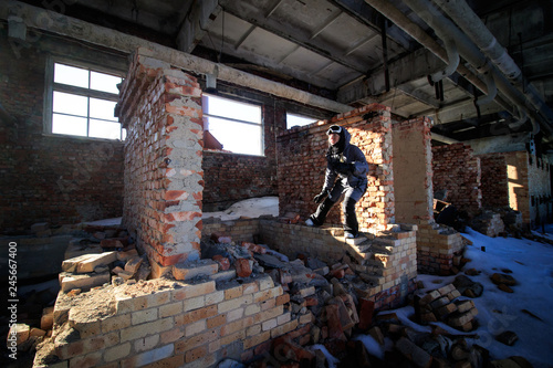 Lonely kid girl in abandoned old children school, oldish walls, forsaken strange left our deserted scenery, film look, atmospheric light of empty destroyed . rooms. Unfinished red stones building