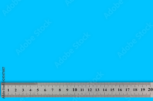 Single metal straightedge with digits and scale on blue background with copy space for your text photo