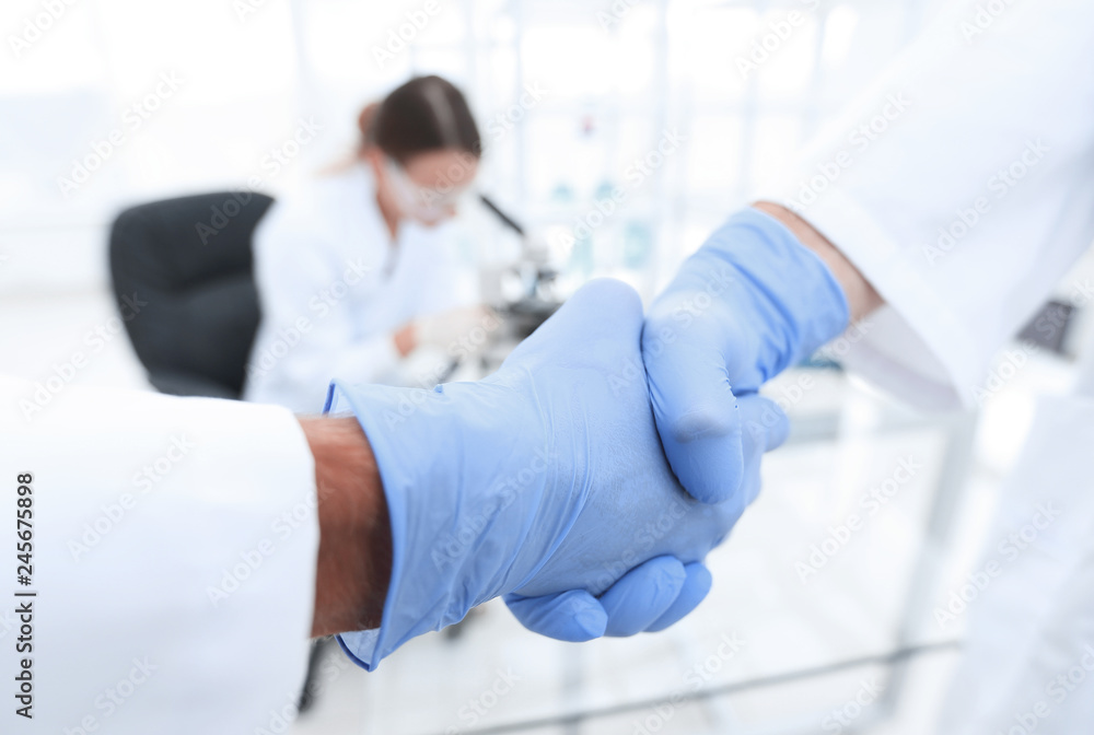 hand in the medical glove (handshake) hand in the medical glove (handshake)