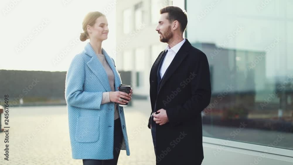 Business people dressed in formal wear talking about work while meeting on the street Business people dressed in formal wear talking about work while meeting on the street