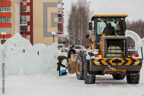 Workers shovels to remove the snow on the ice town