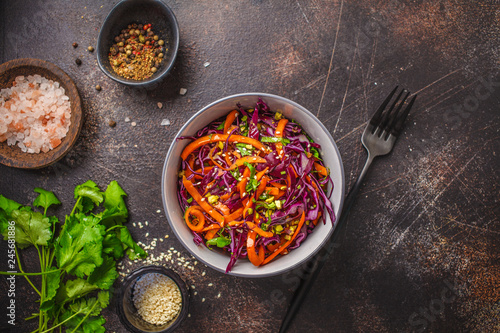 Coleslaw in a gray bowl on dark background. Red cabbage and carrot salad.