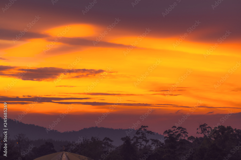 Dramatic bright orange and dark purple sunset sky in the mountains