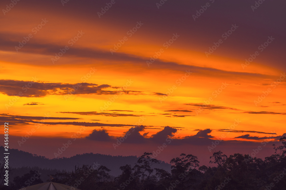 Dramatic bright orange and dark purple sunset sky in the mountains