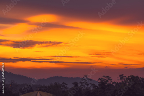 Dramatic bright orange and dark purple sunset sky in the mountains