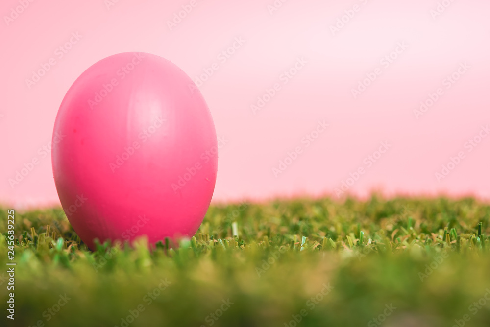 Pink easter eggs clean on grass and pink background
