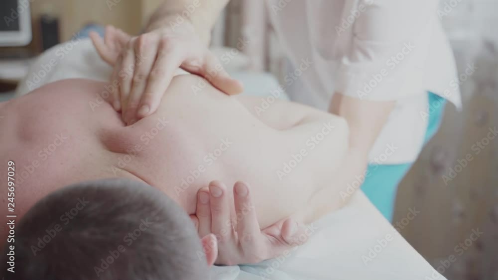 Closeup of Therapist doing back massage an attractive man having a back massage Closeup of Therapist doing back massage an attractive man having a back massage