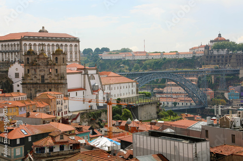 Porto, Portugal. Cityscape of old town with tiled roofs, Ponte Dom Luis I bridge, Saint Lawrence Church (Igreja de Sao Lourenco) and Mosteiro da Serra do Pilar on the background