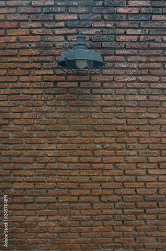 Street lamp hanging on the dirty brick wall background. © Wintakorn