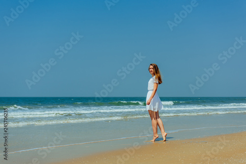 Beautiful Girl in White Dress Enjoy and Relax on The Beach. Travel and Vacation. © exebiche